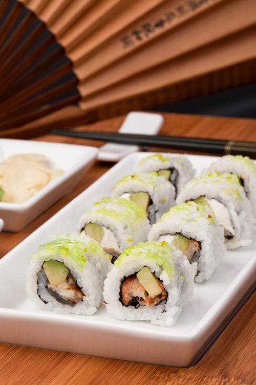 Cucumber maki rolls on a white plate, cut cleanly in cross-section