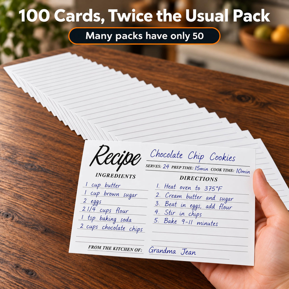 Hand holding a handwritten chocolate chip cookies recipe card above a stack of 100 cards